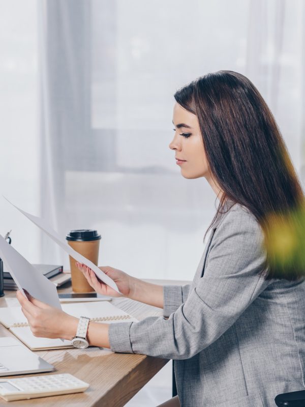 selective-focus-of-recruiter-holding-papers-at-table-in-office.jpg